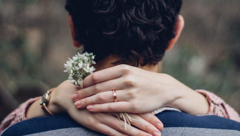 fidanzati che si abbracciano, con anello in primo piano