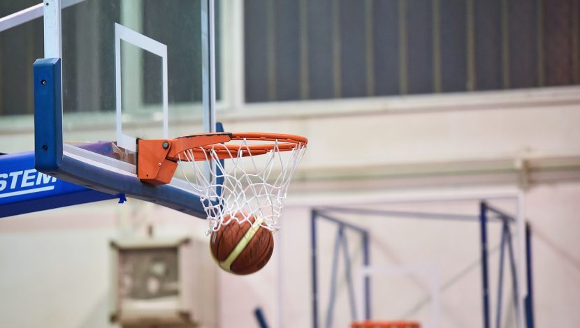 Una palla che esce dal canestro in una palestra di basket, dopo aver segnato un punto