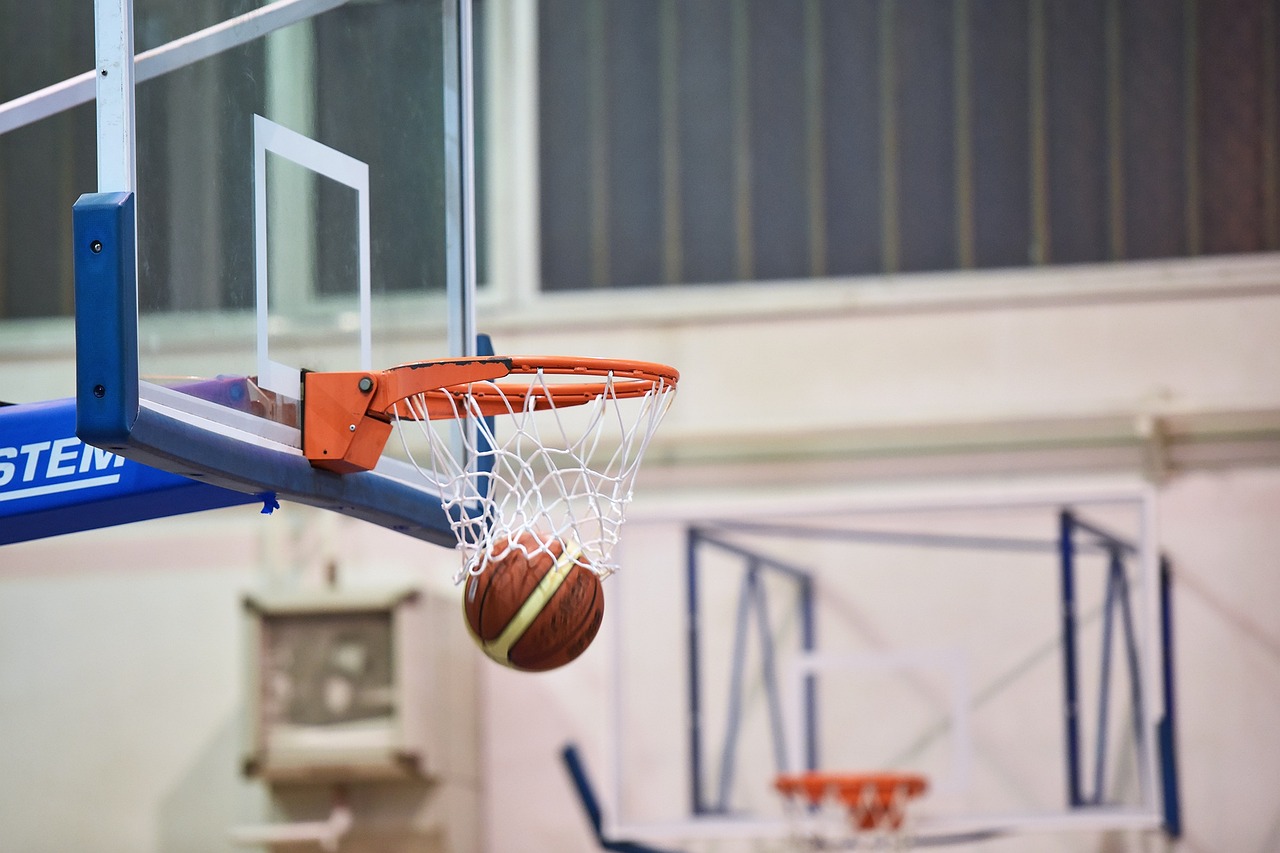 Una palla che esce dal canestro in una palestra di basket, dopo aver segnato un punto