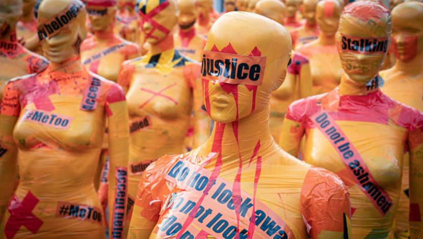 Manichini arancioni con incollate delle scritte riguardanti la violenza sulle donne, come "Justice", °metoo"
