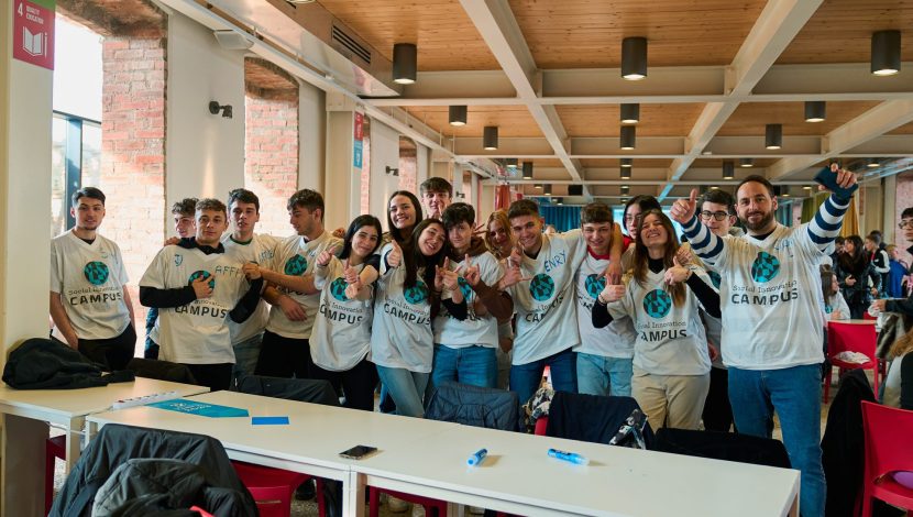 Un gruppo di ragazzi ragazzi con magliette con il disegno della Terra dietro a un tavolo