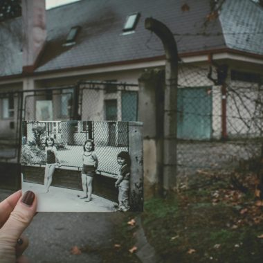 Vecchia foto di bambini davanti a una casa con le finestre sbarrate. Suggerisce idea di adozione e ricerca origini
