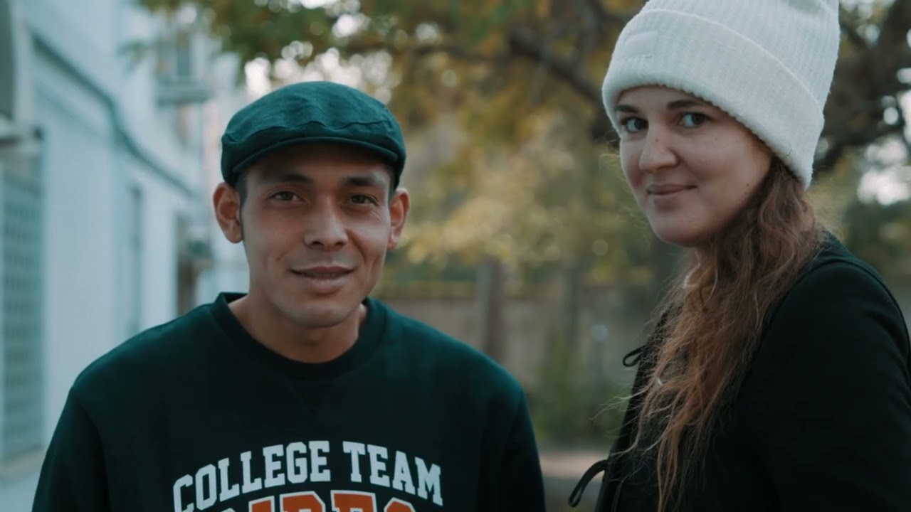 Un ragazzo e una ragazza, entrambi hanno un cappello e guardano in camera