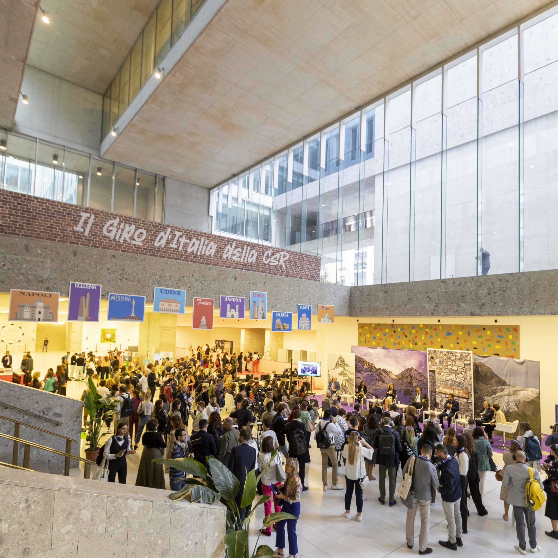 Un edificio da fiera con soffitti alti e vetrate, sotto alcune persone convenute 