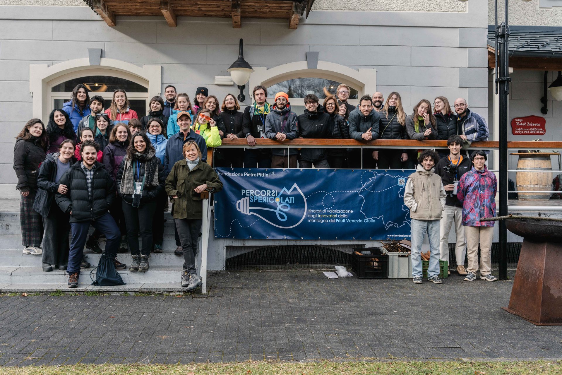 Un gruppo numeroso di persone attorno a un banner con scritto "Percorsi spericolati"