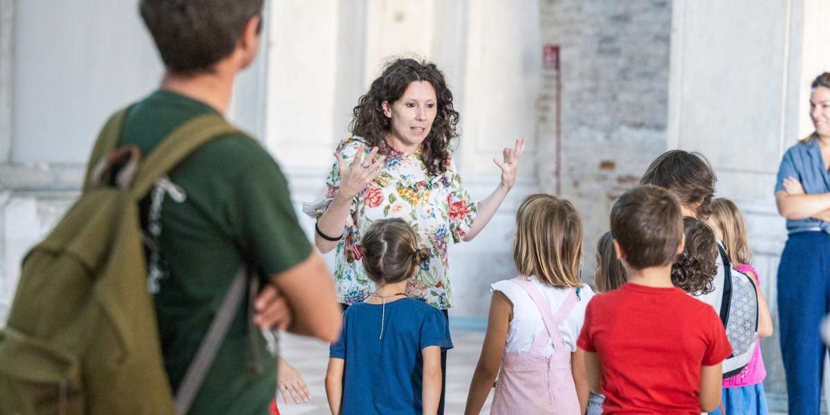 Valeria Bottalico in piedi mentre parla con un gruppo di bambini