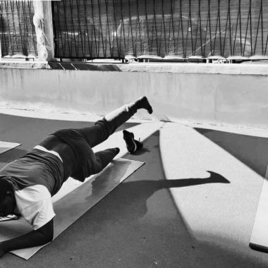 Foto in bianco e nero di una persona che fa esercizi di ginnastica sul tappetino