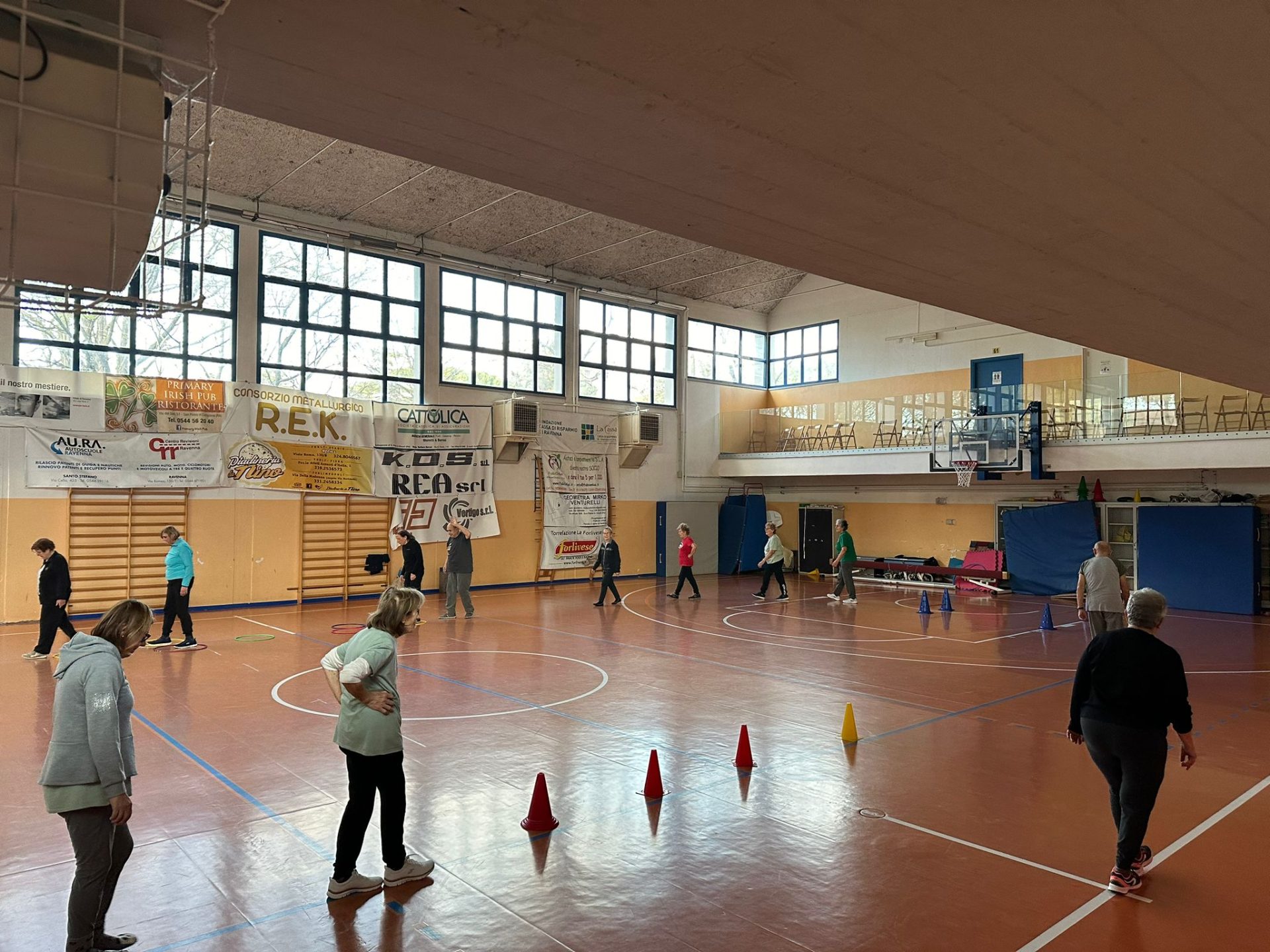 Una palestra in cui ci sono delle persone che camminato, una cammina verso dei coni a terra