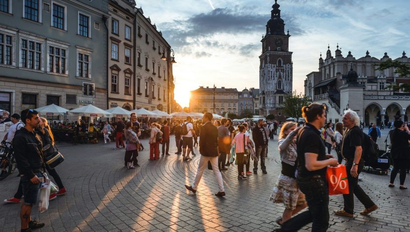 Una piazza di una città italiana al tramonto, ci sono molti turisti che camminano
