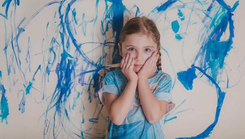 bambina con disegno blu sullo sfondo