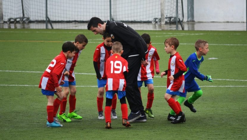 bambini che giocano a calcio, con allenatore