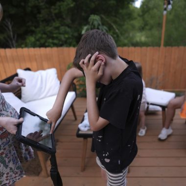 Un ragazzino con diagnosi di autismo, non verbale, comunica con il tablet con la sua caregiver